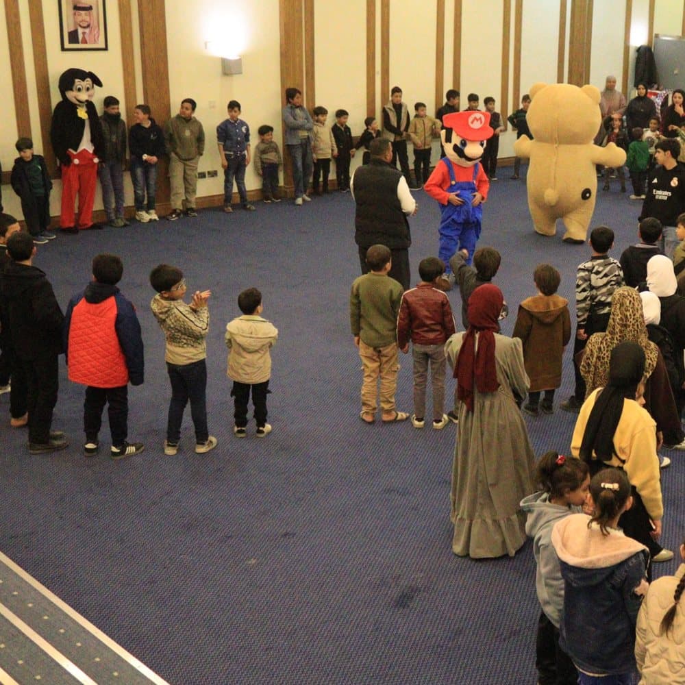 Children gathered in a circle for games with costumed characters