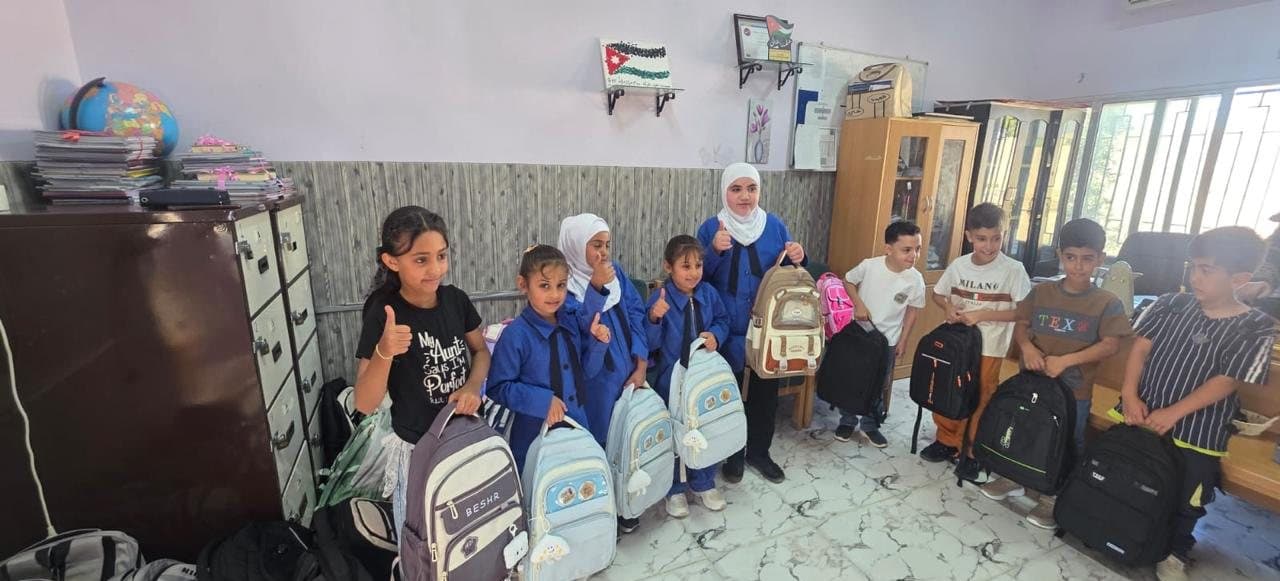 Students holding their new school bags in the school office